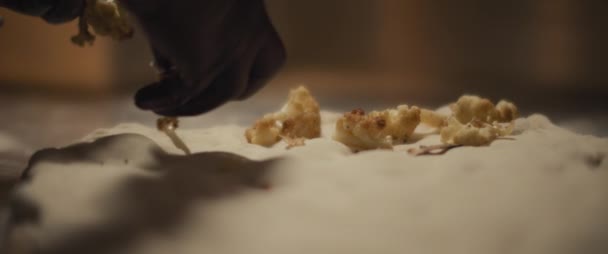 Chef extendiendo coliflor frita sobre una masa de pizza fresca, cámara lenta, de cerca. — Vídeos de Stock