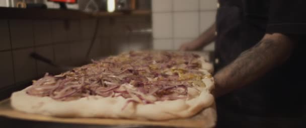 Pizza italienne aux oignons frits placée au four chaud. Mouvement lent. — Video