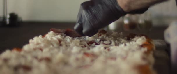 Close up de um chef colocando camada de pepperoni sobre o queijo na tradicional pizza al taglio. — Vídeo de Stock