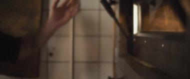 Şef fırın açıyor, pişirmeye hazırlanıyor. Yavaş çekim.