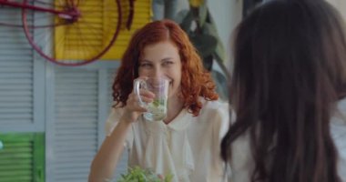 İki bayan meslektaşım çay içiyor, sohbet ediyor ve öğle yemeği molası verirken gülüyorlar. Yavaş çekim, orta çekim..