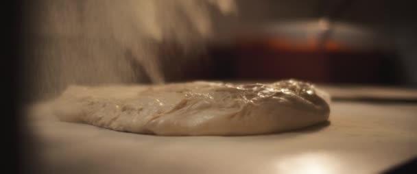 La farina bianca viene distribuita su un impasto fresco impreparato della pizza italiana. — Video Stock