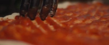 Şef taze pizza al taglio hamuruna geleneksel domates sosu sürüyor. Yaklaşın, ağır çekim.