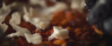 Geleneksel al taglio pizzasının üzerine burrata peyniri serpiştiren bir şefe yaklaş..