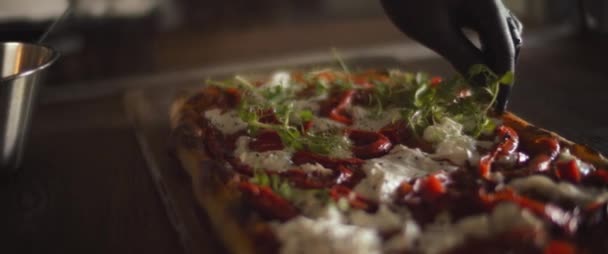 Chef espalhando ervas frescas sobre uma pizza pronta burrata al taglio. Fecha, câmara lenta. — Vídeo de Stock