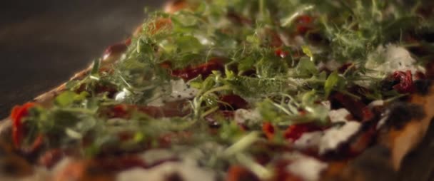 Крупним планом буррата аль-Тагліо піца з сиром, перець і свіжі зелені трави . — стокове відео