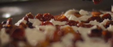 Şef hazır burrata al taglio pizzasının üzerine kırmızı biber yayıyor. Aşırı yakın çekim, yavaş çekim