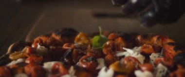 Şef hazır burrata al taglio pizza üzerine fesleğen yaprakları yayıyor. Yaklaşın, ağır çekim.