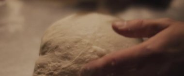 Şef geleneksel pizza hamurunun şeklini kontrol ediyor. Yaklaşın, ağır çekim.