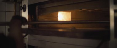 Pizza fırınını temizleyen bir şefin yavaş çekim çekimi..