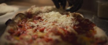 Şef geleneksel al taglio pizzasının üzerine mozzarella peyniri sürüyor. Yavaş çekim.