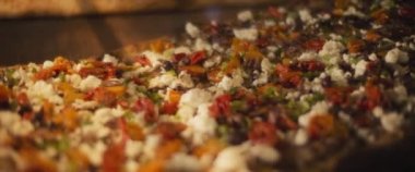 Farklı malzemelerle lezzetli al taglio pizzaları bir pizza kafede ahşap bir yüzeye yerleştiriliyor. Yavaş çekim