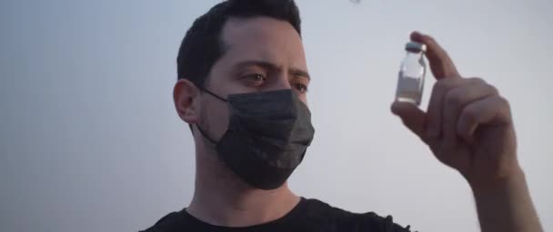 Ein Mann Mit Schwarzer Maske Hält Eine Flasche Impfstoff Der — Stockvideo