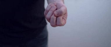 Bir adamın kapalı eli Covid 19 aşı şişesini göstermek için açılır.