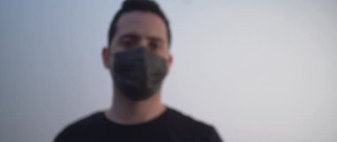 Elinde aşı tutan siyah maskeli bir adam.