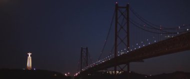 Portekiz, Lizbon 'daki Tagus Nehri üzerindeki 25 de Abril köprüsünün gece görüşü. Yavaş çekim.