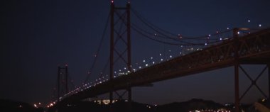 Lizbon 'daki Tagus Nehri' ni geçen büyük asma köprü üzerinde gece görüşü. Yavaş çekim.