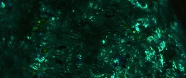 Yeşil ve mavi top şeklindeki yapışkan madde yavaş çekimde kameraya doğru genişliyor.