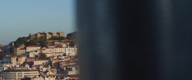 Lizbon, Portekiz 'deki tepedeki antik ortaçağ taş kalesi, kırmızı çatıları olan geleneksel binaların üstünde. Yavaş çekim.