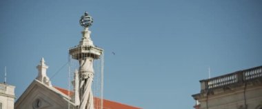 Lizbon, Portekiz 'deki tarihi bölge binalarının ve heykellerin üzerinde uçan bir kuş. Yavaş çekim