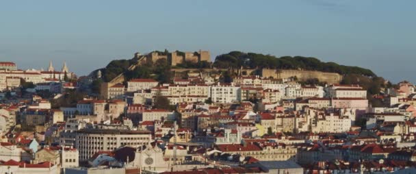 ポルトガルのリスボンの丘の上 赤い屋根のある伝統的な建物の上にある古代の石の要塞のパノラマビュー スローモーション — ストック動画