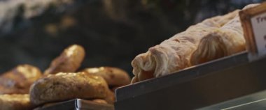 Kafe vitrininde taze ekmek ve poğaça tatlısı. Ağır çekim, yakın çekim.,