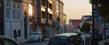 Günbatımında renkli binaları olan tipik Lizbon caddesi. Yavaş çekim.