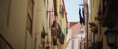 Lizbon 'da güzel renkli apartmanlı dar bir caddenin manzarası. Yavaş çekim.