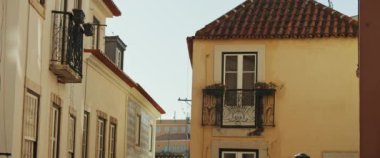 Güneşli bir günde eski bir Avrupa tarzı konut binasının sarı cephesi. Yavaş çekim.