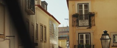 Güneşli bir günde eski bir Avrupa tarzı konut binasının ön cephesini boyadı. Yavaş çekim.