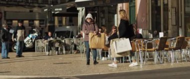 Lisbon, Portugal - Dec. 07, 2019: People walking down the street with shopping bags, slow motion.