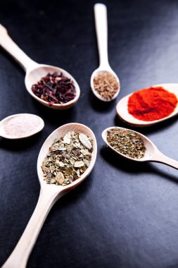 siyah bir zemin üzerine tahta kaşık baharat. Gıda