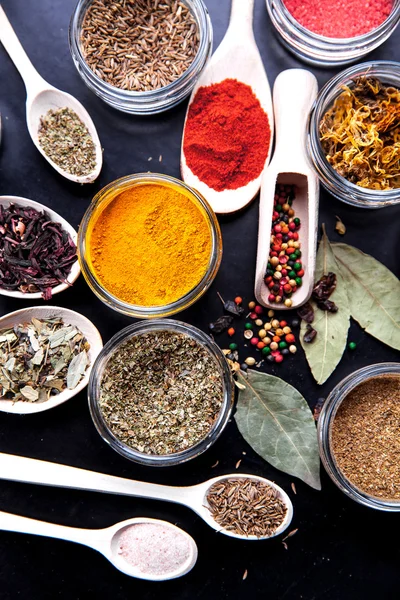 Spices on black background in special jars. Food — Stock Photo, Image