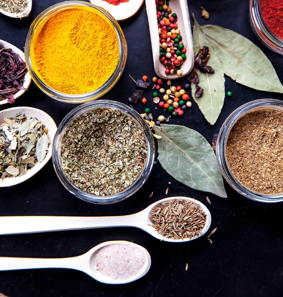 Spices on black background in special jars. Food — Stock Photo, Image