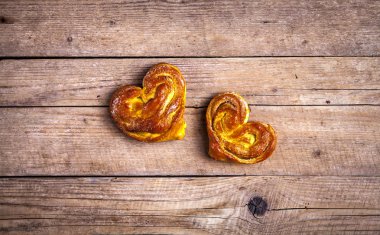 Ev yapımı hamur işleri. Ahşap arka plan üzerinde topuz kalp. Gıda