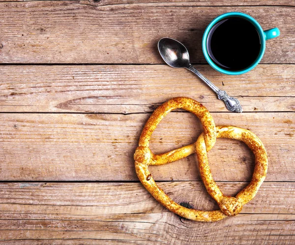 Delicioso desayuno, un pretzel con café sobre fondo de madera . —  Fotos de Stock