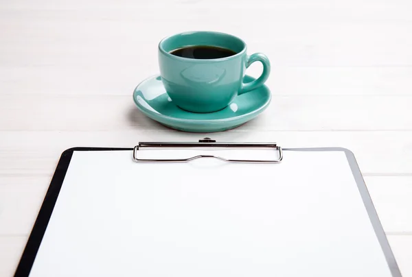 Appunti con pagina bianca e tazza di caffè sulla scrivania in legno. Vista dall'alto . — Foto Stock