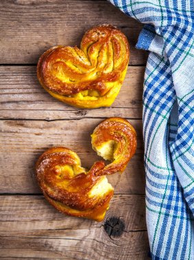Ev yapımı hamur işleri. Topuz kalp mutfak havlu üzerinde ahşap backgr ile