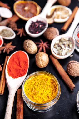 siyah arka plan üzerine baharat ile tahta kaşıklar