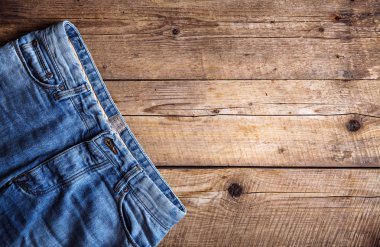 Ahşap arka plan üzerinde kot pantolon. Üst kısmı. Giyim, moda, Stil, yaşam biçimi