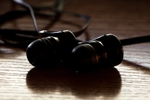 Auriculares negros en una mesa de madera. Escucha, estilo —  Fotos de Stock