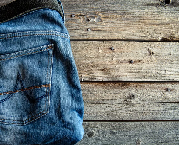 Calça jeans bem dobrada em fundo de madeira. Vestuário, moda, estilo, estilo de vida — Fotografia de Stock