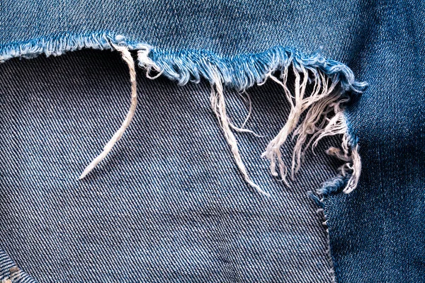Textura jean azul con un agujero y los hilos que muestran —  Fotos de Stock