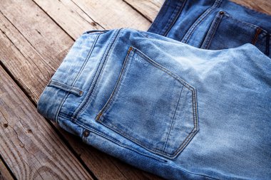 Mavi jeans kahverengi ahşap arka plan üzerinde.