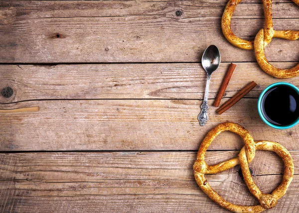 Leckeres Frühstück, eine Brezel mit Kaffee auf Holzuntergrund. — Stockfoto