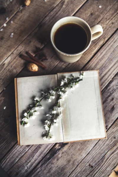 Grande xícara de café no fundo de madeira vintage. Flores e livros de primavera . — Fotografia de Stock