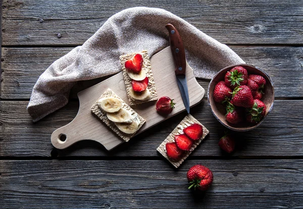 Fruchtiger Toast auf hölzernem Hintergrund. Erdbeeren, Brot, Butter und — Stockfoto