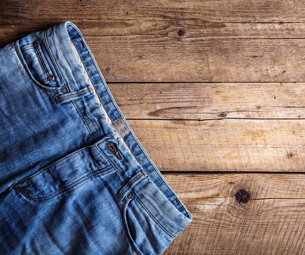 Jeans on a wooden background. The upper part. Clothing, fashion, style, lifestyle