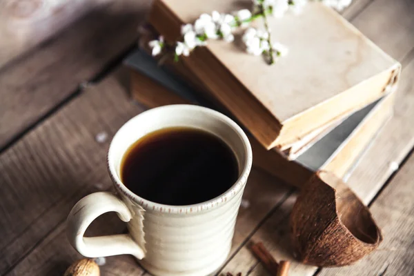 Große Tasse Kaffee auf Vintage-Holzgrund. Frühlingsblumen und Bücher. — Stockfoto