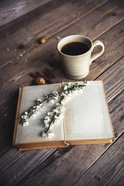 Große Tasse Kaffee auf Vintage-Holzgrund. Frühlingsblumen und Bücher. — Stockfoto